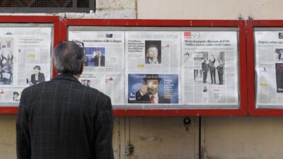 Old man looking at local newspapers